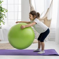 kid-training-with-gym-ball-full-shot